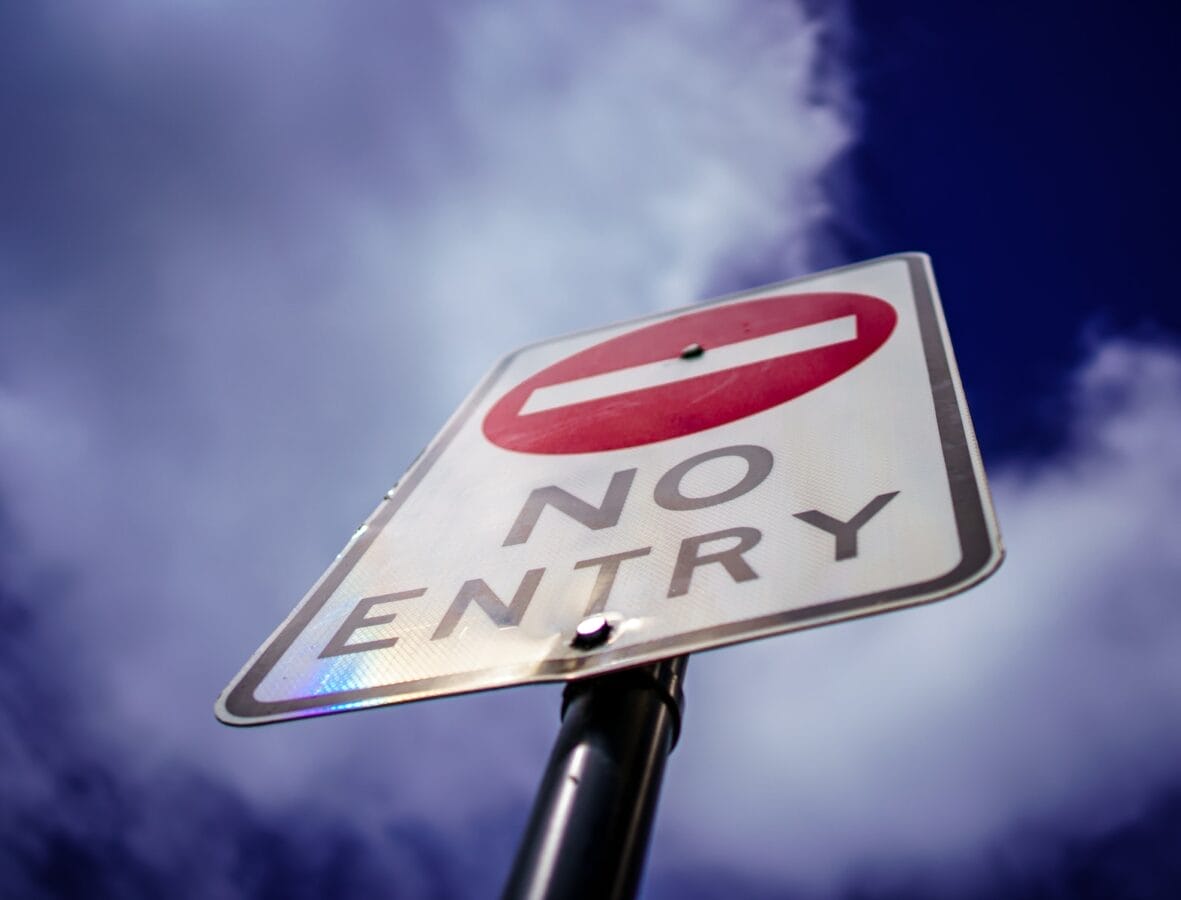 a no entry sign is shown against a blue sky