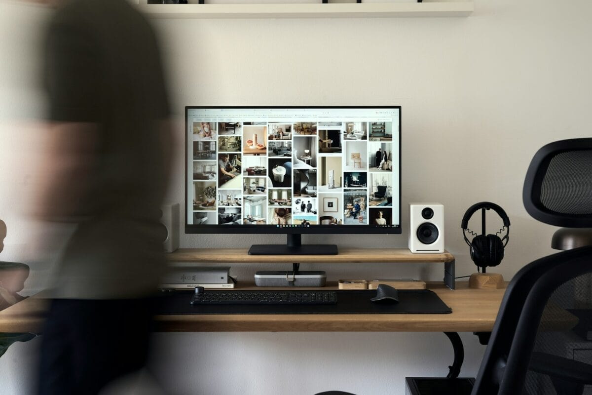 A blurry photo of a person standing in front of a computer