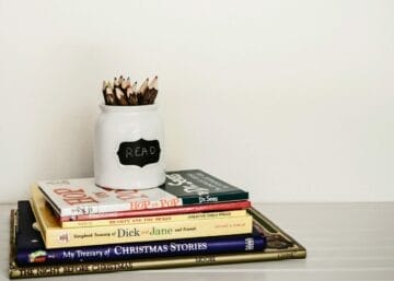 white ceramic pencil organizer on top of stack of books