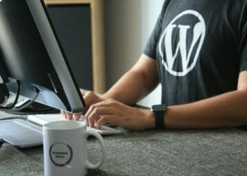 person in black and white t-shirt using computer