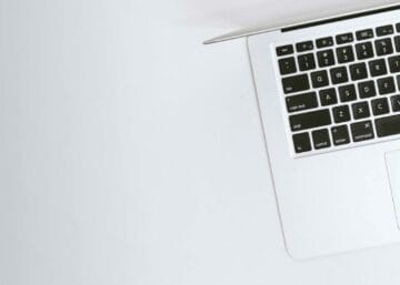 Aerial view of a sleek laptop keyboard on a clean, white surface, ideal for tech backgrounds.